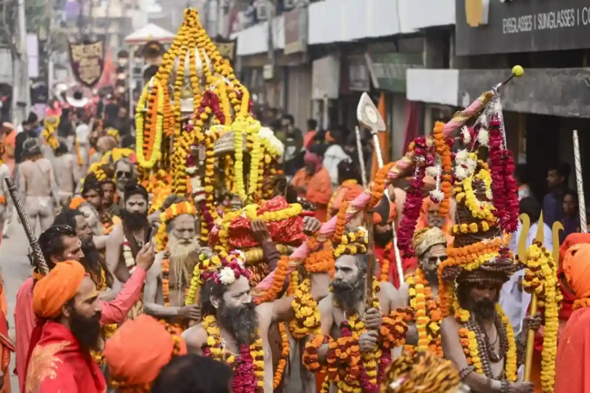 Peshwai Akharas entry into Kumbh city; decorated elephants/horses; saffron flags; disciplined march of sadhus; large crowd watching